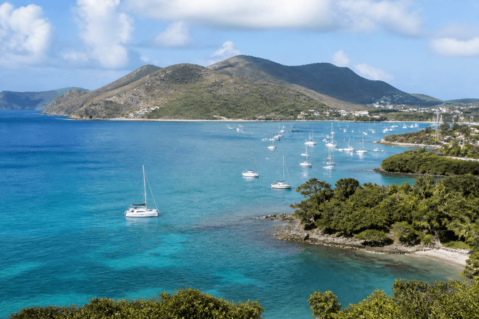 Caribbean harbor with turquoise water and green hills