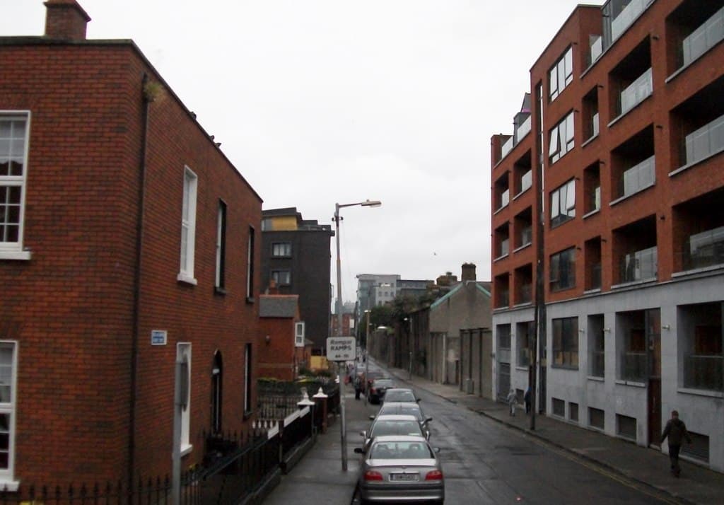 Apartment blocks on a wet Dublin street beside older brick housing